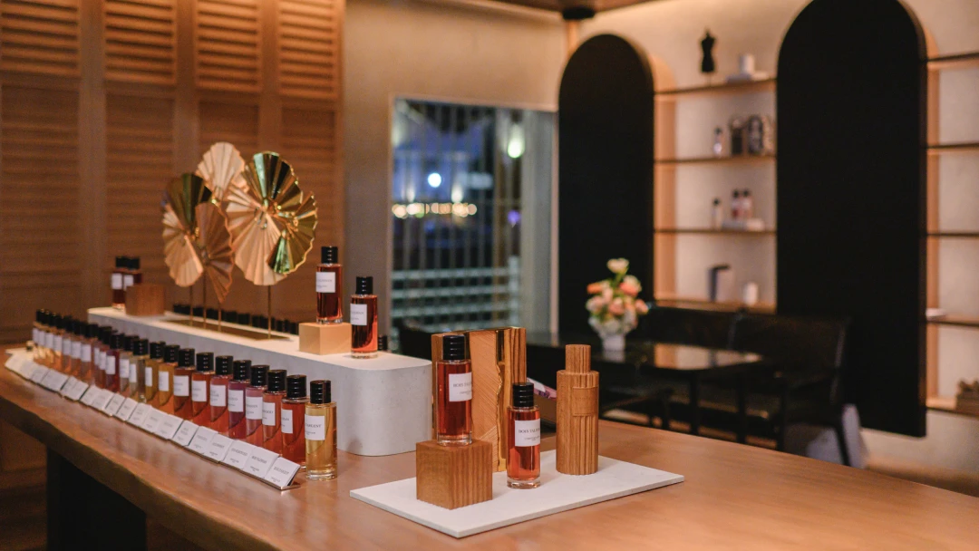 different scents displayed on a wooden table in a perfume store
