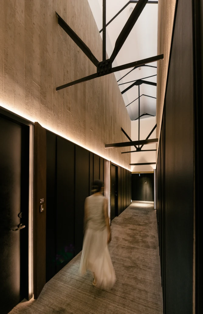 post-heritage-experience-1-1 woman in a white dress walking in a narrow hallway