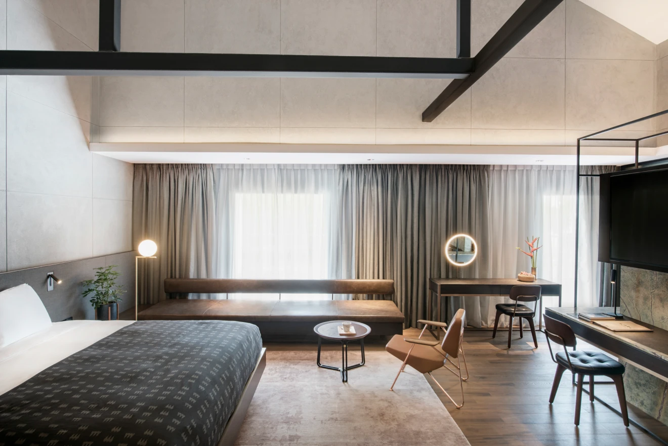 spacious hotel bedroom with grey and brown accents