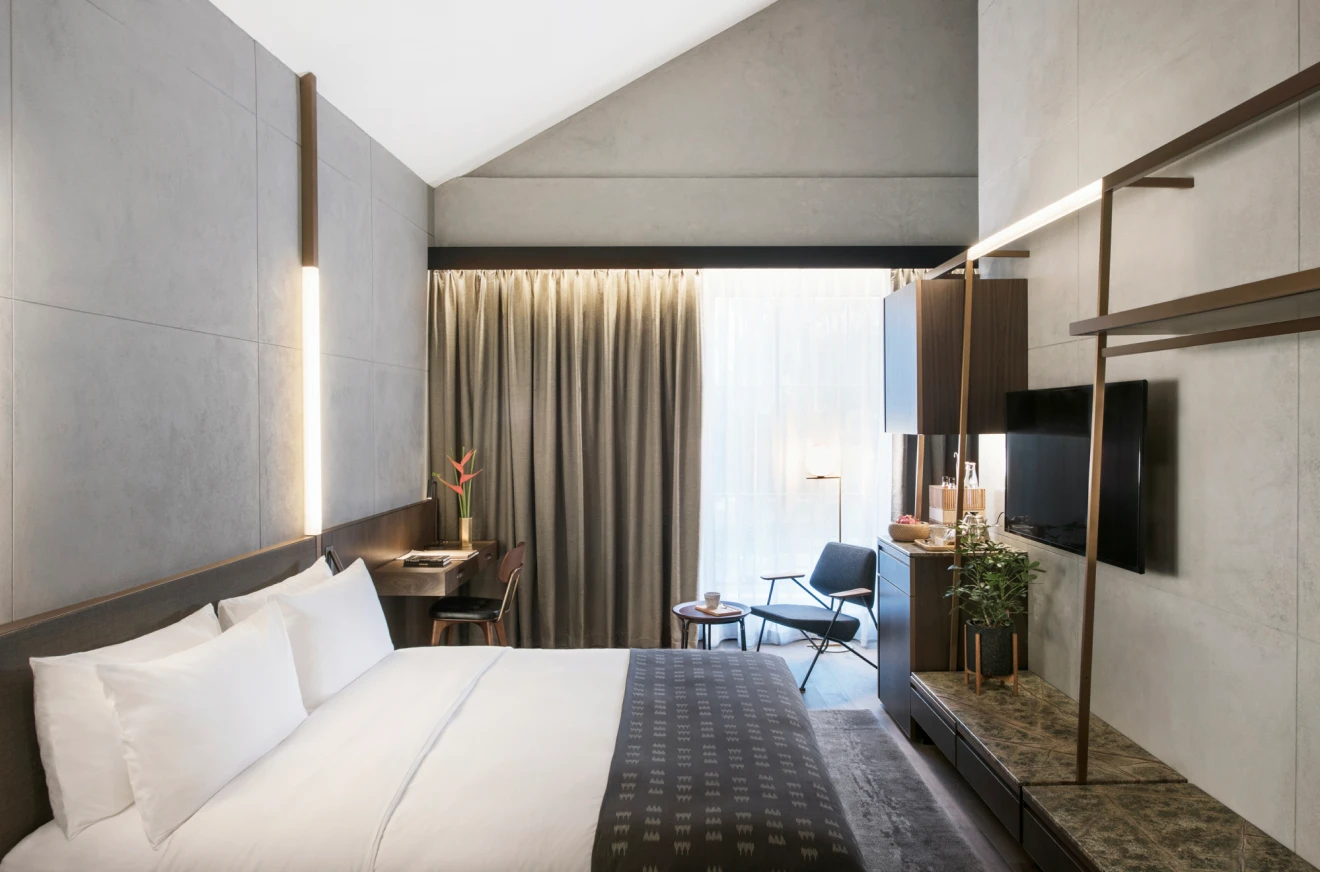 hotel bedroom with spacious bed, large windows, and open closet